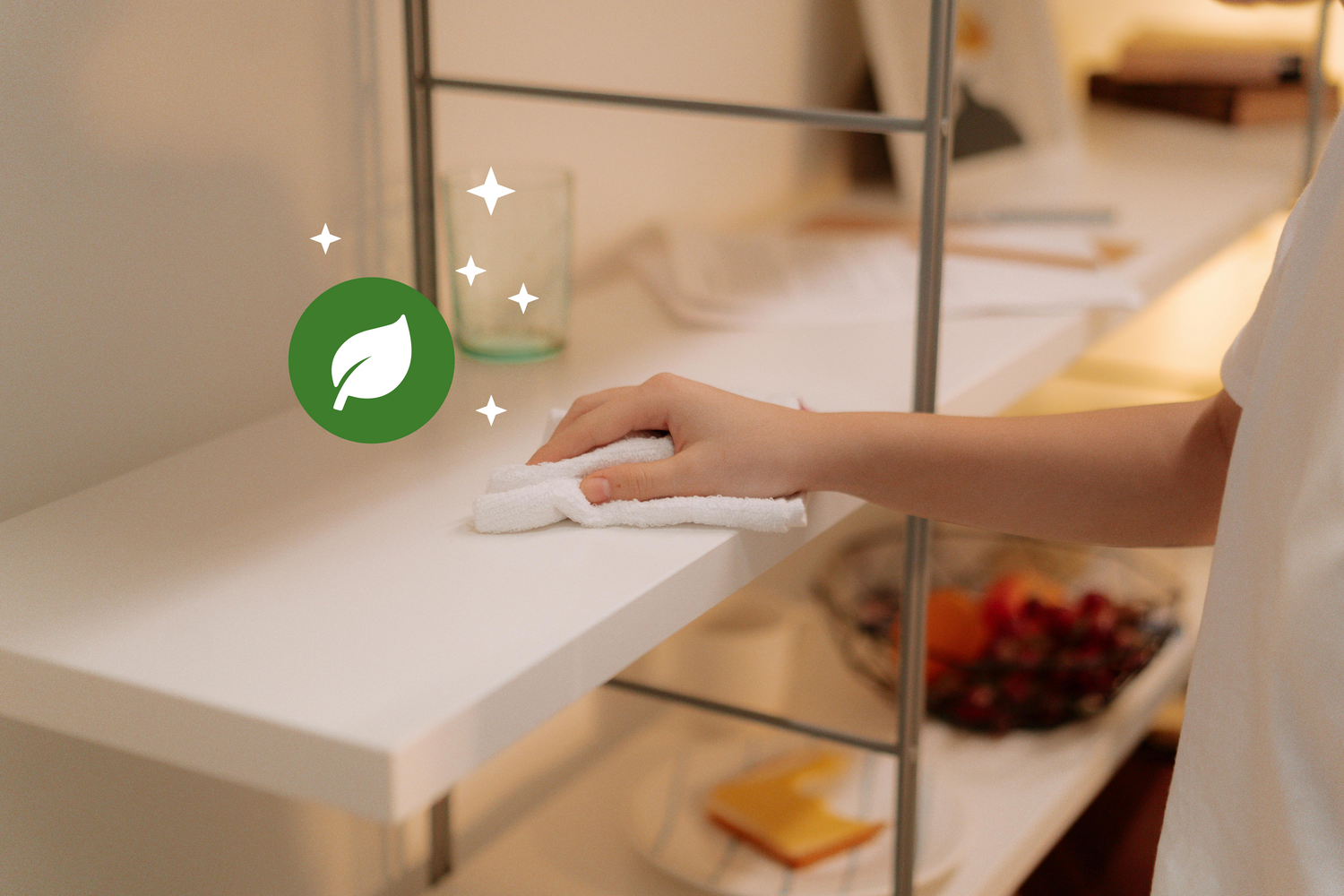 Hand wiping a white shelf with cloth; green leaf icon and sparkles highlight EcoVin’s eco‑friendly, streak‑free cleaning.